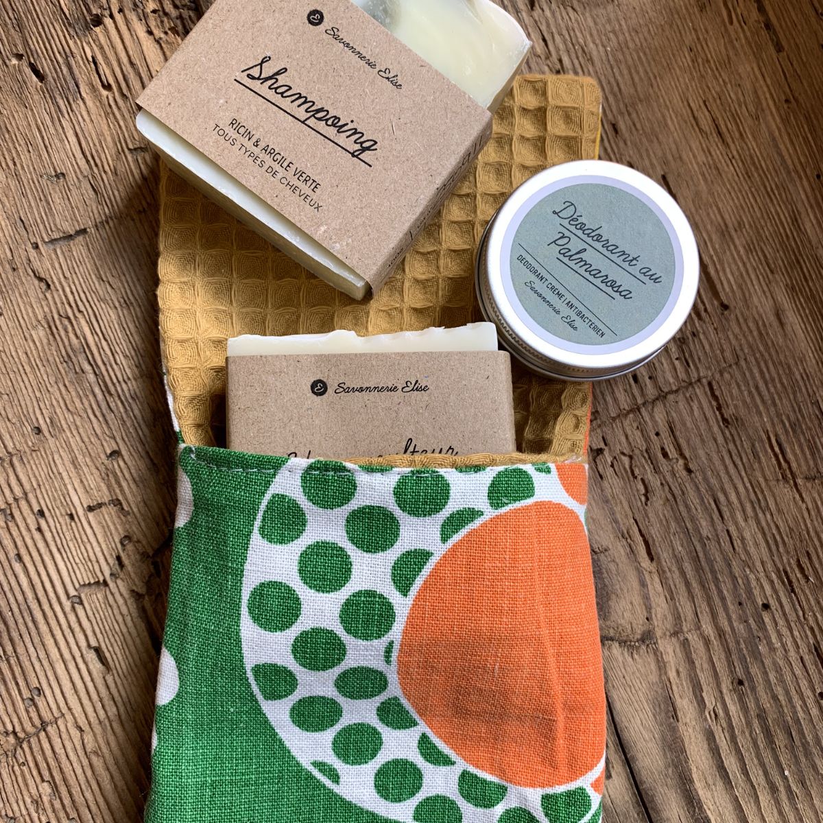 Kit voyage zéro déchet Savonnerie Elise comprenant un shampoing solide, un savon au miel, un déodorant voyage et une pochette en tissu